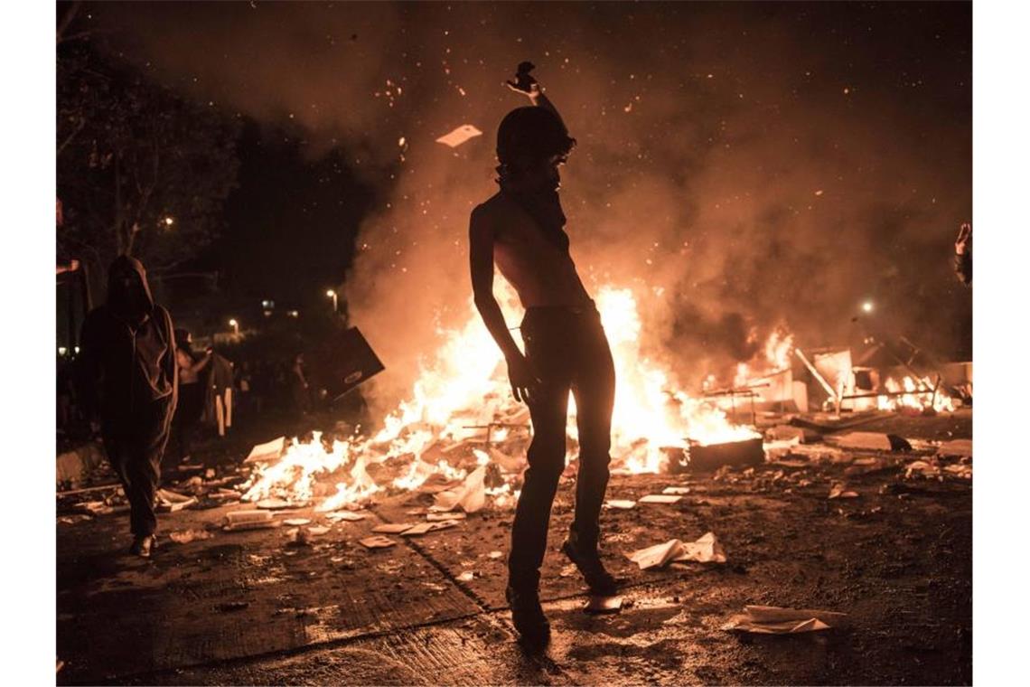 Demonstrant vor einer brennenden Barrikade. Foto: Adrien Vautier/Le Pictorium Agency via ZUMA/dpa