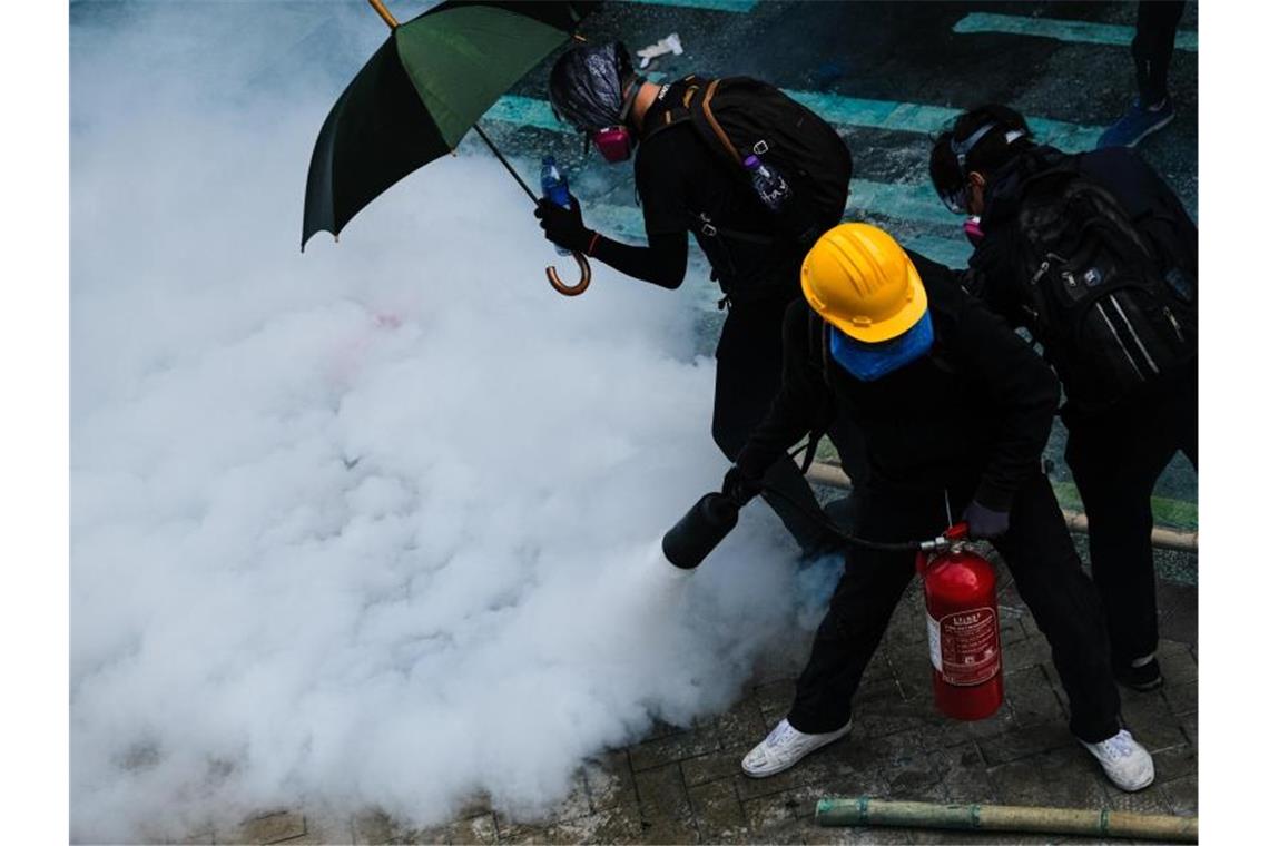 Hongkong: US-Kongress stellt sich hinter Demokratiebewegung Demonstranten bekämpfen Tränengas mit einem Feuerlöscher. Foto: Keith Tsuji/ZUMA Wire/dpa