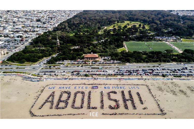 Demonstranten bilden ein menschliches Banner "We have eyes - no more lies - Abolish" am Ocean Beach in San Francisco während eines Protests gegen die US-Einwanderungsbehörde ICE.