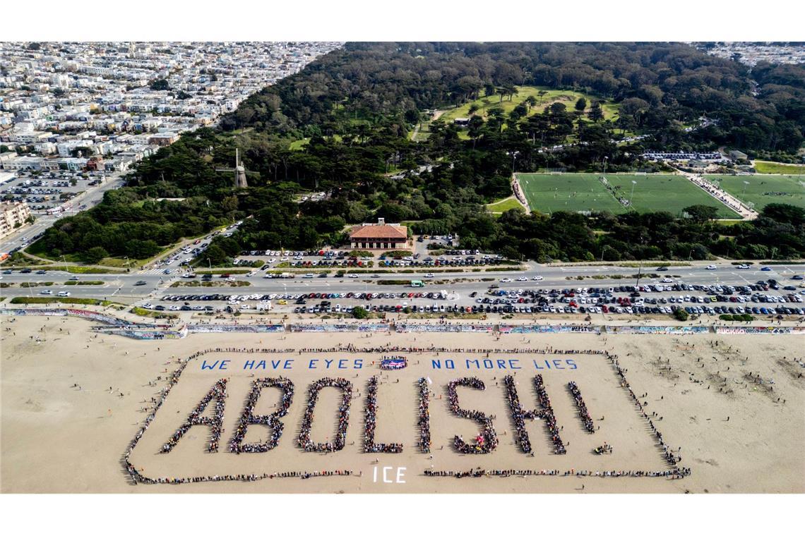 Demonstranten bilden ein menschliches Banner "We have eyes - no more lies - Abolish" am Ocean Beach in San Francisco während eines Protests gegen die US-Einwanderungsbehörde ICE.