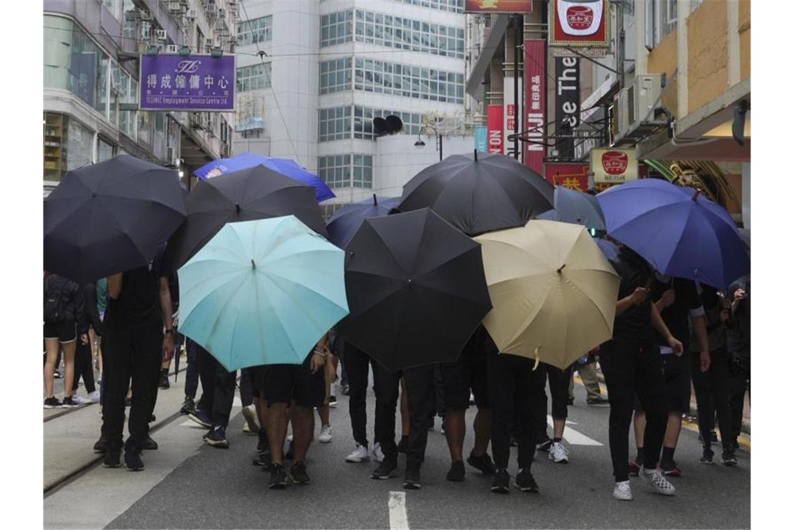 China droht Großbritannien wegen Hongkong-Einmischung Demonstranten bilden ein Schutzschild aus Regenschirmen. Foto: Vincent Yu/AP/dpa