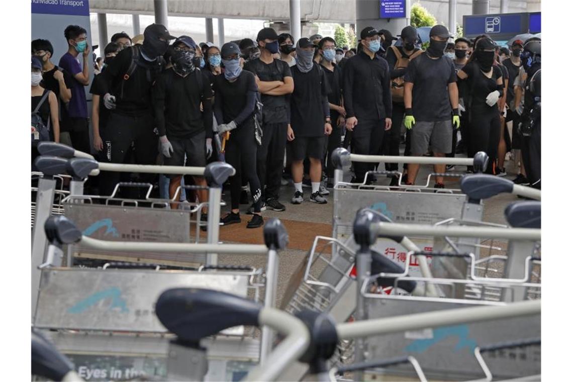 China verurteilt Gewalt in Hongkong - 159 Festnahmen Demonstranten blockieren eine Straße vor dem Hongkonger Flughafen. Foto: Kin Cheung/AP
