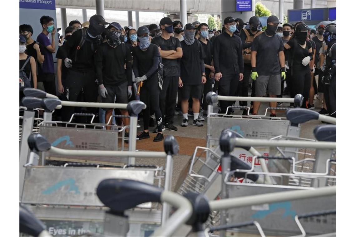 Demonstranten blockieren eine Straße vor dem Hongkonger Flughafen. Foto: Kin Cheung/AP