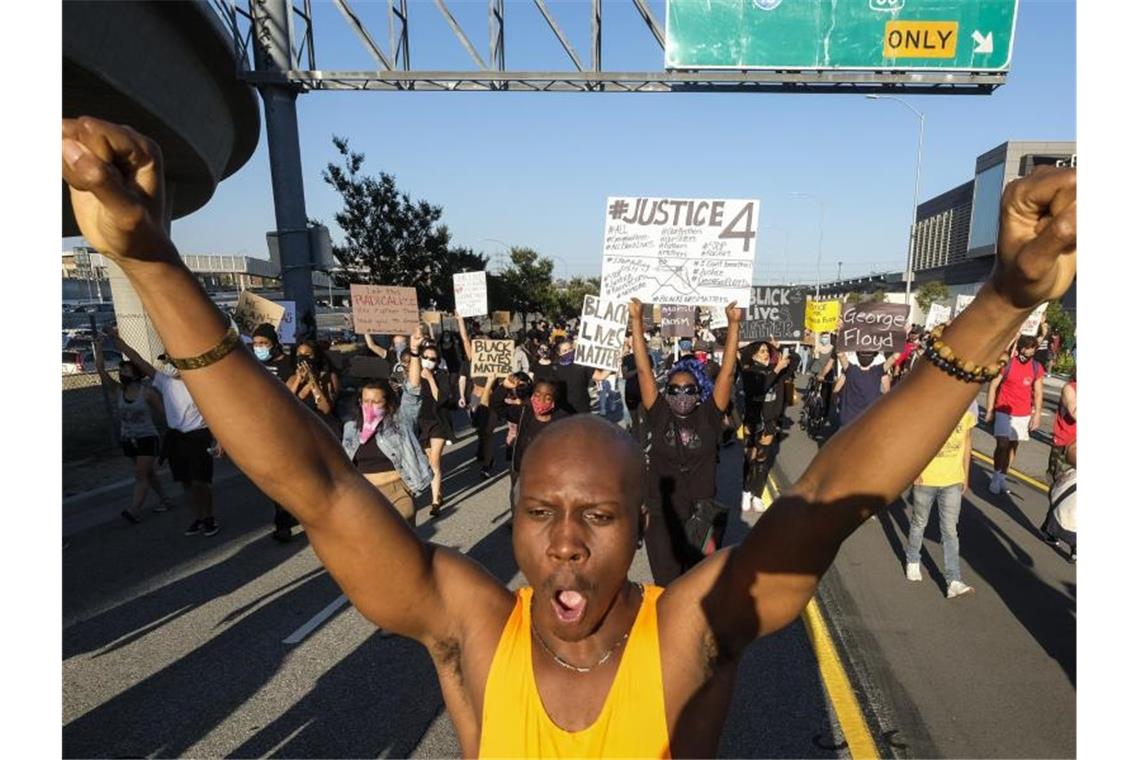 Trump: Untersuchung im Fall von Afroamerikaner angeordnet Demonstranten fordern Gerechtigkeit für den Tod des Afroamerikaners ein. Foto: Ringo H.W. Chiu/AP/dpa