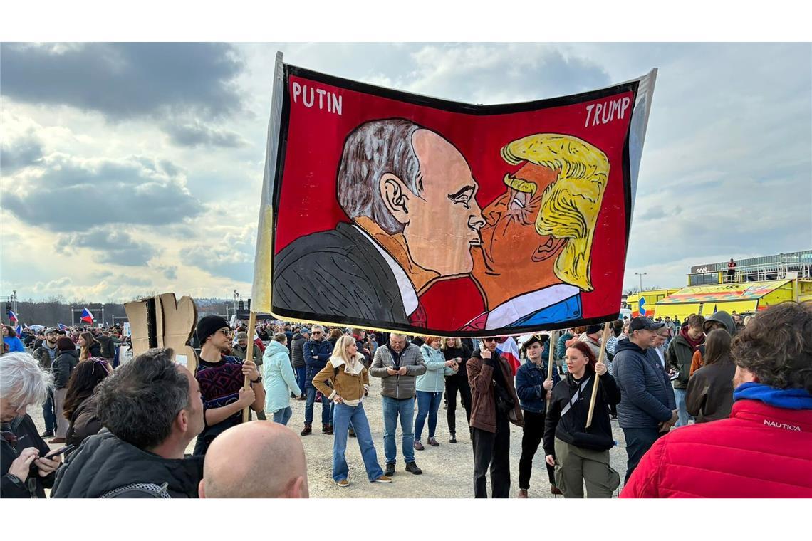 Demonstranten halten bei einer Kundgebung des Bündnisses "Eine Million Augenblicke für Demokratie" ein Banner, auf dem sich stilisiert US-Präsident Trump und Russlands Präsident Putin küssen.
