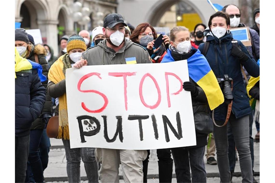 Demonstranten halten ein Plakat mit der Aufschrift "Stop Putin" bei einer Friedensdemo. Foto: Tobias Hase/dpa/Archivbild