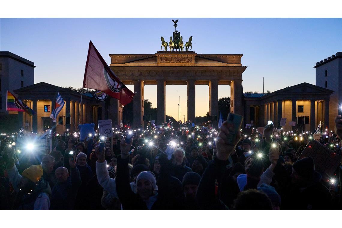 Bilder des Tages Demonstranten halten ihre Handys mit Taschenlampen vor dem Brandenburger Tor in die Luft. Die Demonstration unter dem Motto "Brandmauer hoch! Wir sind das Stadtbild" bezieht sich auf eine Äußerung von Bundeskanzler Merz im Zusammenhang mit der Migrationspolitik.