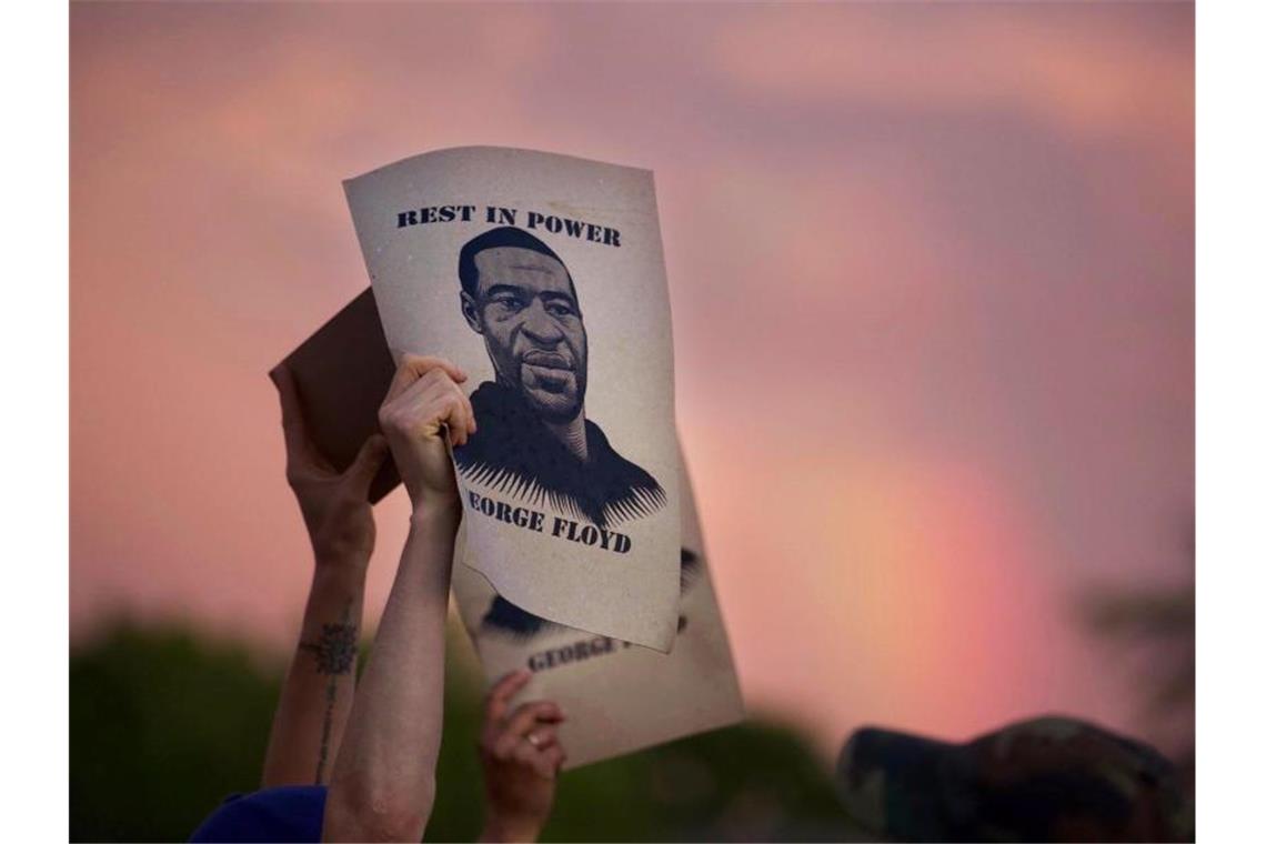 Demonstranten halten während eines Protestes ein Porträt von George Floyd in die Höhe. Foto: Christine T. Nguyen/Minnesota Public Radio/AP/dpa