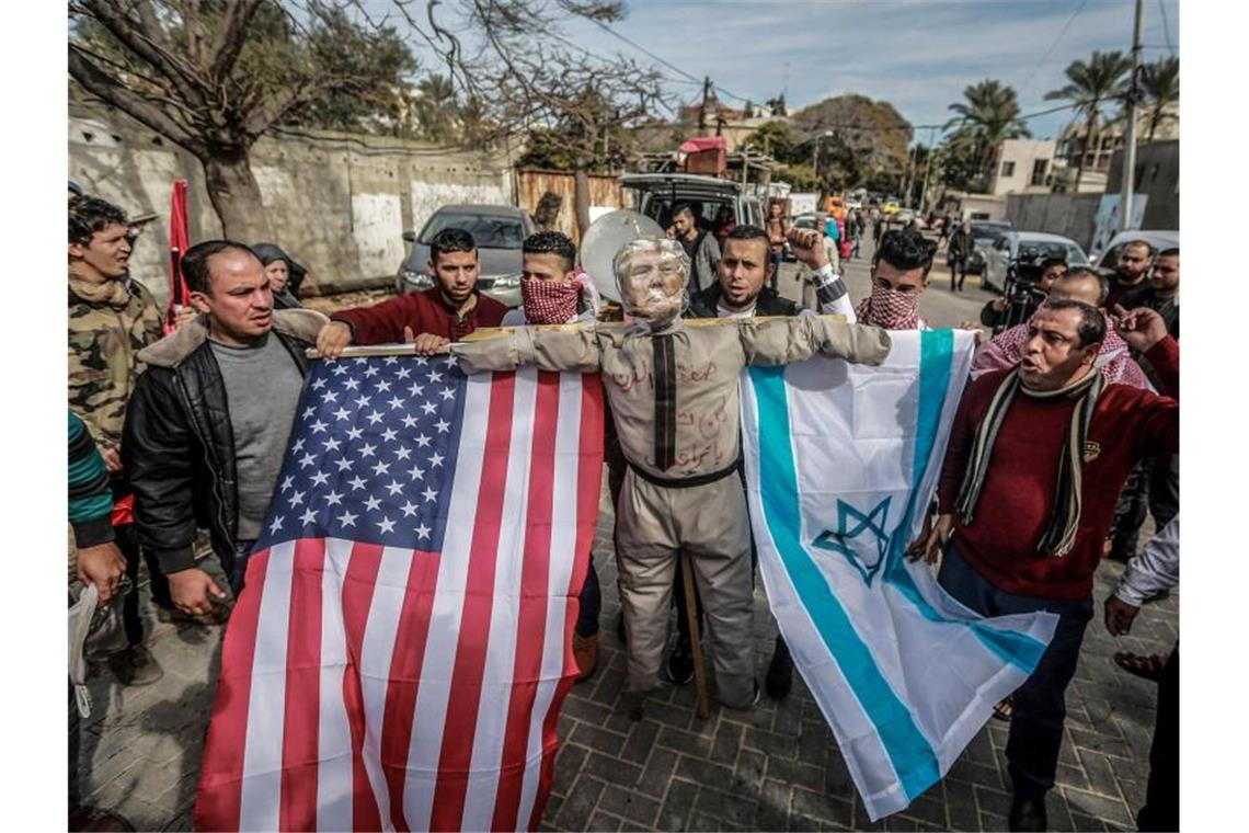 Demonstranten im Gazastreifen tragen während eines Protestes eine als US-Präsident Trump verkleidete Strohpuppe. Foto: Mohammed Talatene/dpa