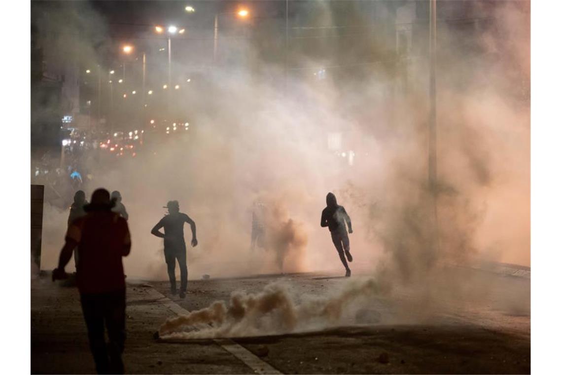 Keine Entspannung in Sicht - neue Angriffswelle in Israel Demonstranten in Bethlehem fliehen vor den ätzenden Schwaden der Tränengaskanister, die die israelische Grenzpolizei gegen sie eingesetzt hatte. Foto: Luay Sababa/XinHua/dpa