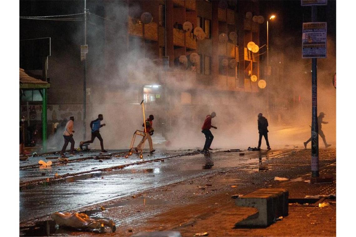 Militäreinsatz nach gewaltsamen Protesten in Südafrika Demonstranten in Johannesburg laufen weg, nachdem die Polizei Tränengaskanister eingesetzt hat. Foto: Yeshiel/XinHua/dpa