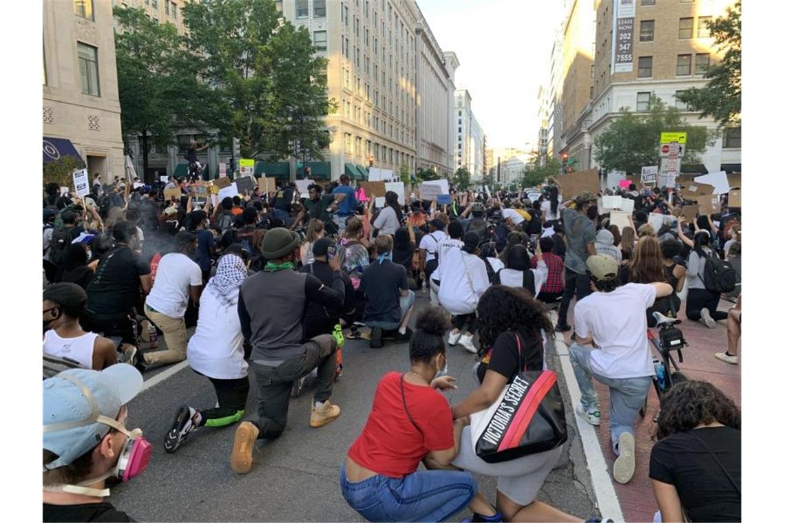 Demonstranten knien als Zeichen des Protests in der Hauptstadt Washington auf einer Straße. Foto: Can Merey/dpa