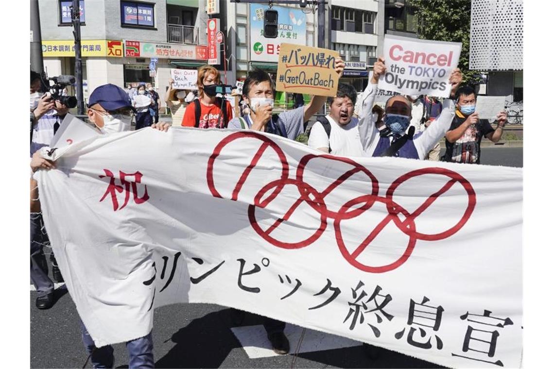 Misstrauen und Verdruss - Japan skeptisch zu Olympia Demonstranten marschieren mit einem Banner und Plakaten bei einem Protest gegen die Olympischen und Paralympischen Sommerspiele. Foto: Koji Harada/Kyodo News/AP/dpa