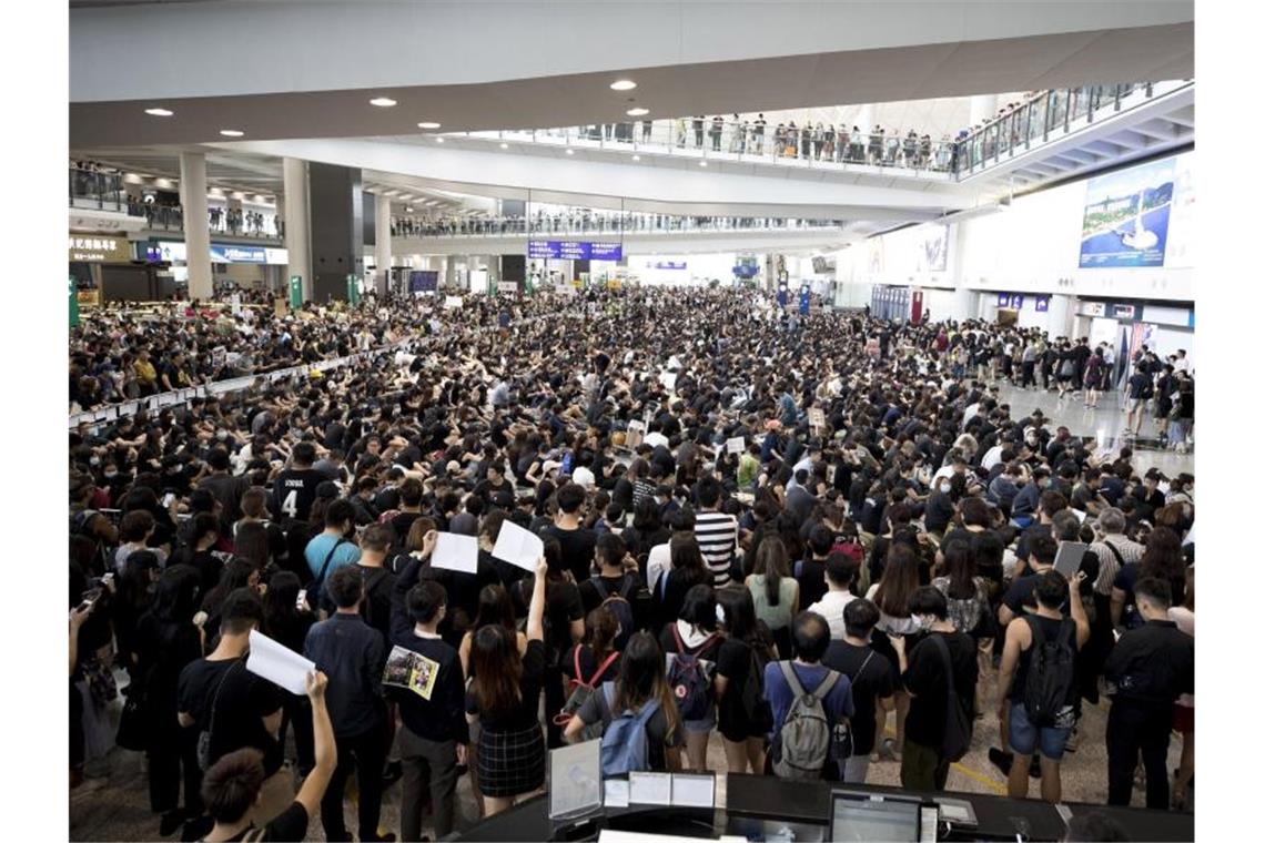 Heftige Zusammenstöße in Hongkongs Flughafen Demonstranten protestieren in der Ankunftshalle des Flughafens gegen die Regierung und die Polizeigewalt bei vergangenen Protesten. Foto: Vincent Thian/AP
