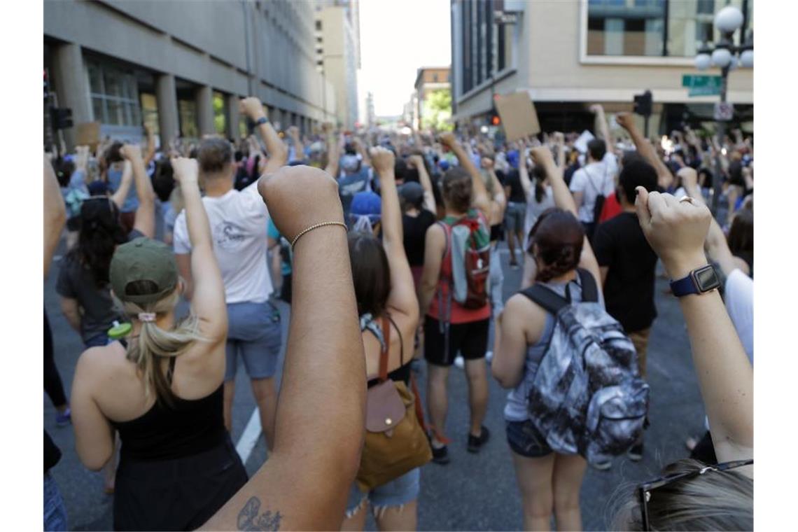 Demonstranten protestieren in der Nähe der Stadt Minneapolis und erheben solidarisch ihre Faust. Nach dem Tod des Afroamerikaners George Floyd bei einer brutalen Festnahme hat die Stadt Minneapolis erste Reformen ihrer Polizei auf den Weg gebracht. Foto: Julio Cortez/AP/dpa