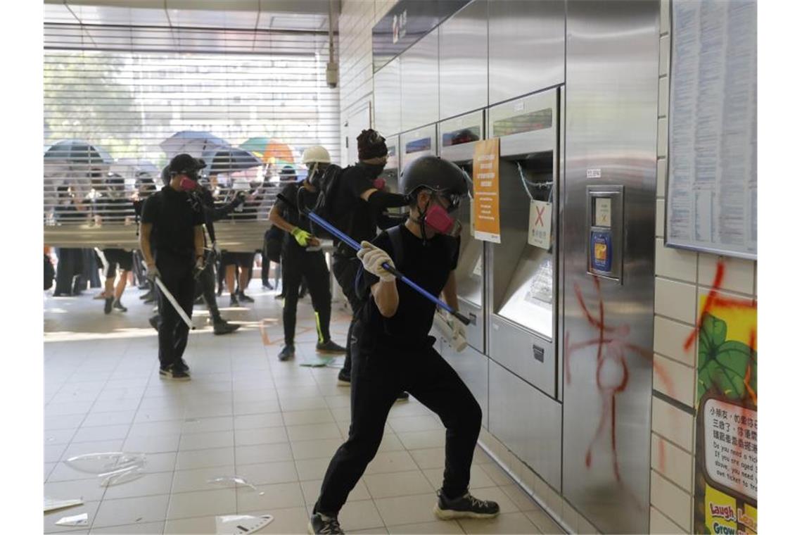 Demonstranten randalieren in der Eingangshalle einer Hongkonger U-Bahn-Station. Foto: Kin Cheung/AP/dpa