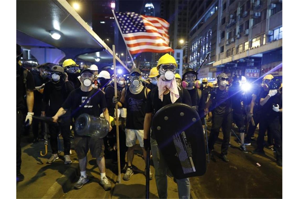 Neue Ausschreitungen in Hongkong Demonstranten schwenken eine US-Flagge und bereiten sich auf die Konfrontation mit der Polizei vor. Foto: Vincent Yu/AP