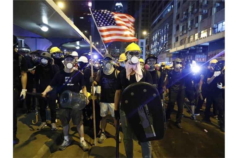 Demonstranten schwenken eine US-Flagge und bereiten sich auf die Konfrontation mit der Polizei vor. Foto: Vincent Yu/AP