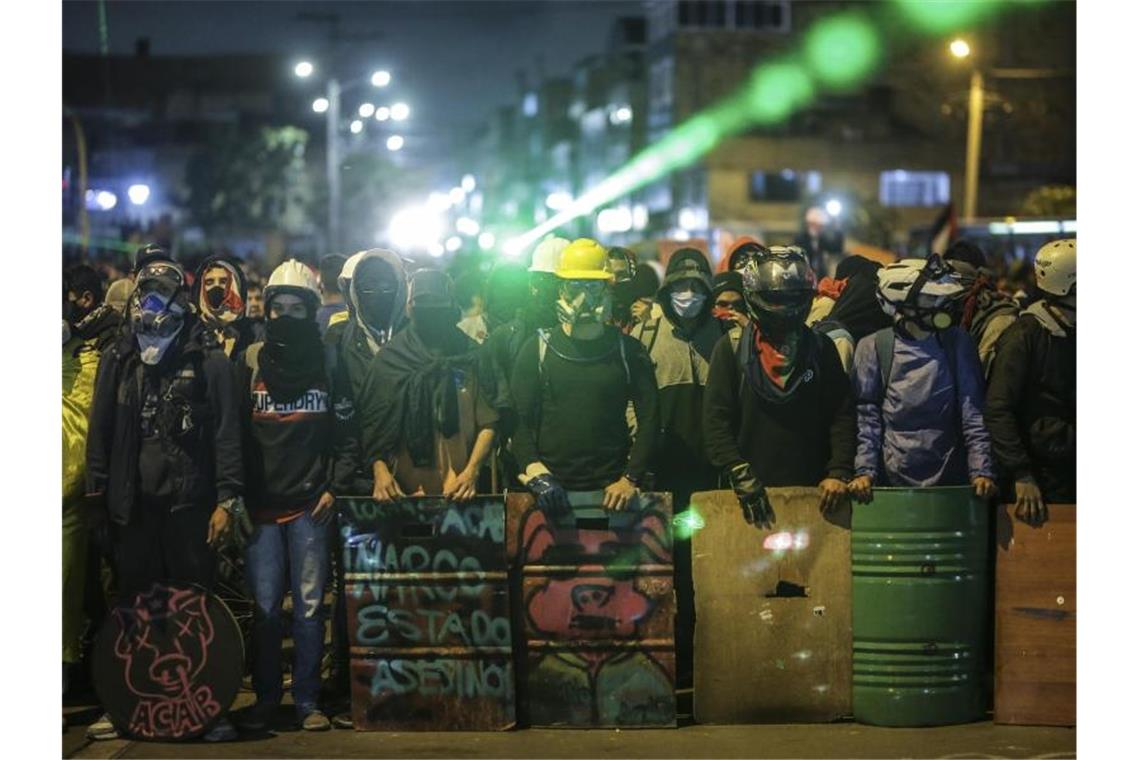 Kolumbiens Außenministerin Blum tritt zurück Demonstranten stehen bei einem Protest an einer Kreuzung mit Schildern und Laserpointern. Foto: Ivan Valencia/AP/dpa