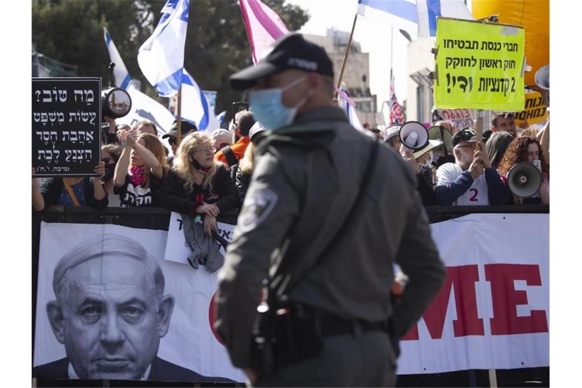 Demonstranten stehen mit Bannern und Plakaten vor dem Bezirksgericht in Jerusalem. Foto: Maya Alleruzzo/AP/dpa