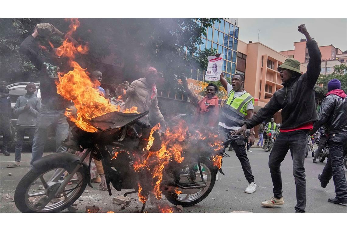Bilder des Tages Demonstranten stehen vor einem brennenden Motorrad während einer Demonstration gegen die Regierung aus Anlass des Todes eines populären Bloggers in Polizeigewahrsam in Kenia.