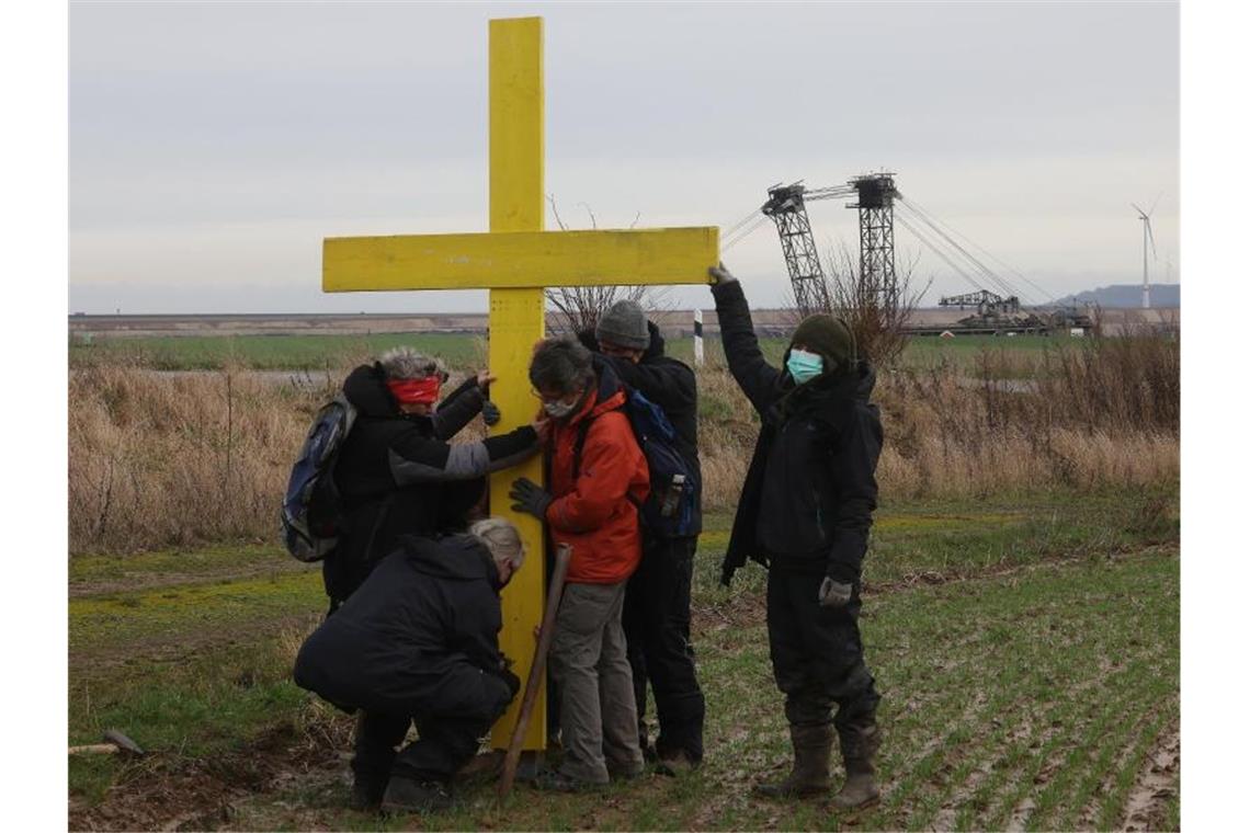 Hunderte bei Aktionstag für Tagebaudorf Lützerath Demonstranten stellen am Rande des Braunkohletagebaus bei Lützerath ein gelbes Kreuz auf. Foto: Oliver Berg/dpa