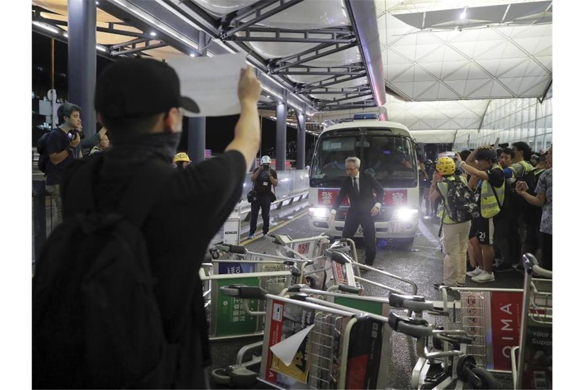 China verschärft in der Hongkong-Krise den Ton Demonstranten stellen sich am Flughafen von Hongkong einem Polizeiwagen in den Weg. Foto: Kin Cheung/AP