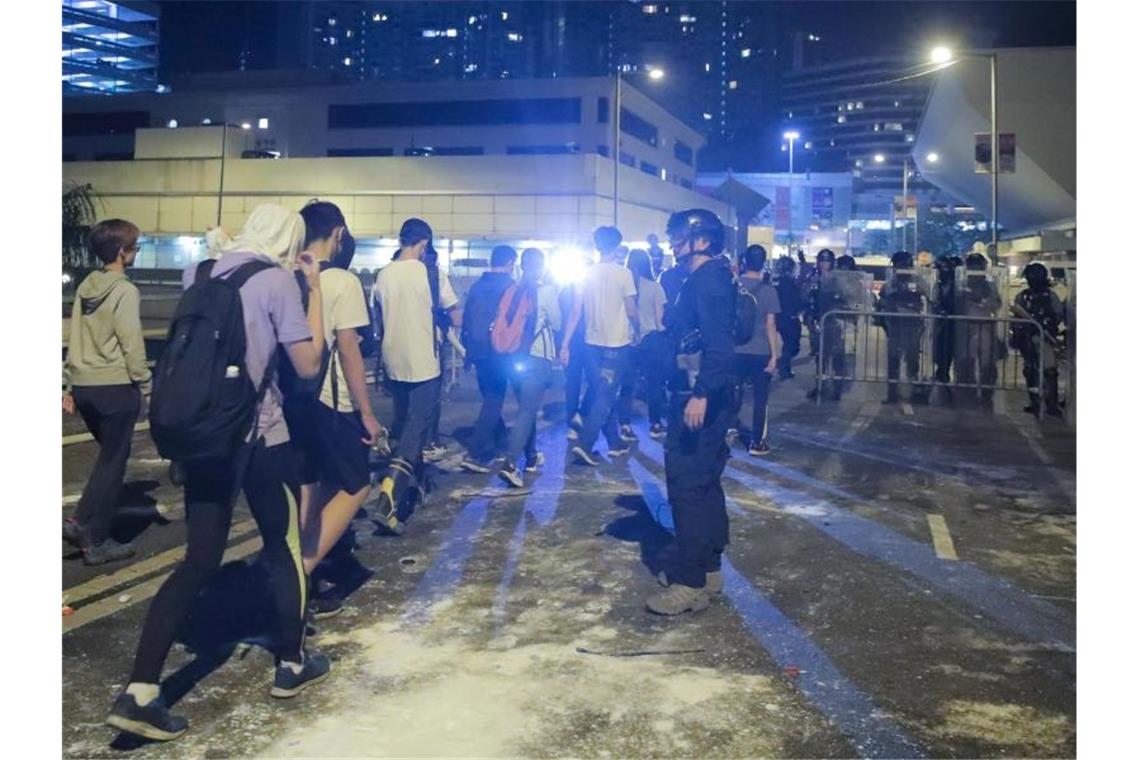 Demonstranten stellen sich der Polizei außerhalb des Campus. Foto: Kin Cheung/AP/dpa