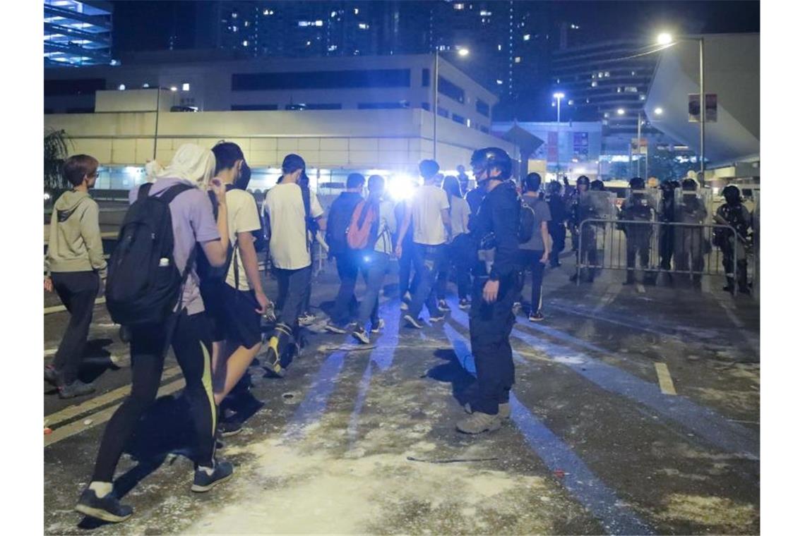 Hongkong: US-Kongress stellt sich hinter Demokratiebewegung Demonstranten stellen sich der Polizei außerhalb des Campus. Foto: Kin Cheung/AP/dpa