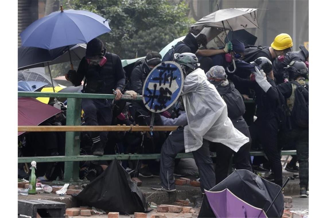 Demonstranten stellen sich Polizisten entgegen. Foto: Achmad Ibrahim/AP/dpa