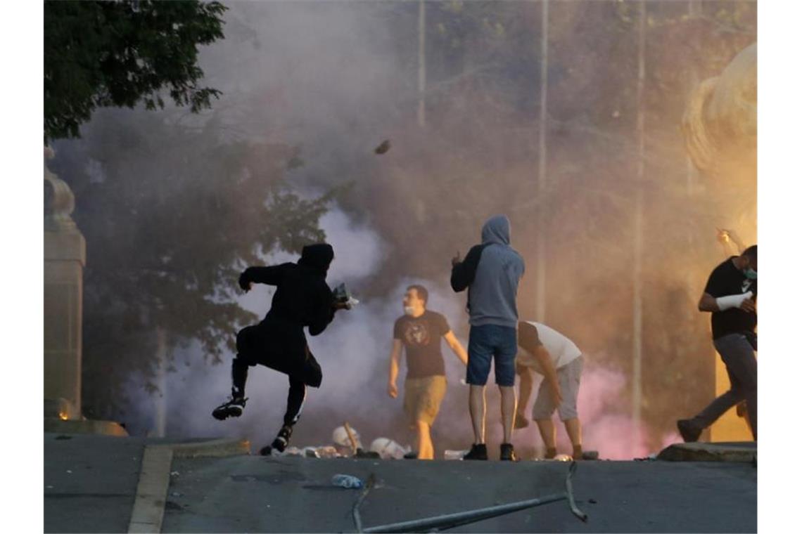 Demonstranten stoßen bei Protesten in Belgrad mit Polizisten zusammen. Foto: Darko Vojinovic/AP/dpa