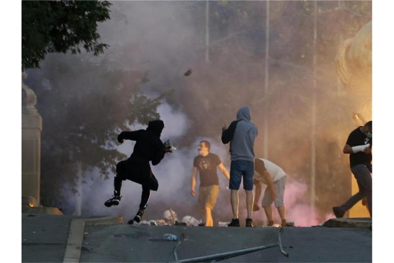 Demonstranten stoßen bei Protesten in Belgrad mit Polizisten zusammen. Foto: Darko Vojinovic/AP/dpa