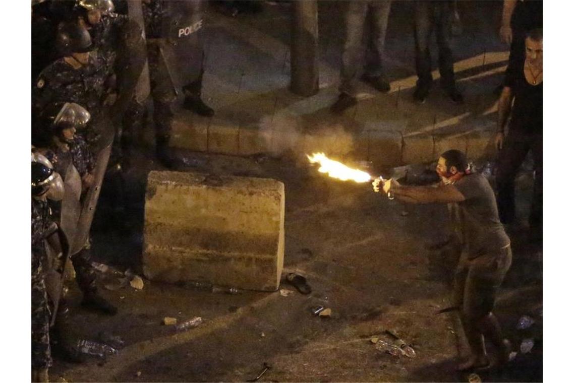 Tausende protestieren im Libanon Demonstranten stoßen mit Polizisten. Foto: Hassan Ammar/AP/dpa