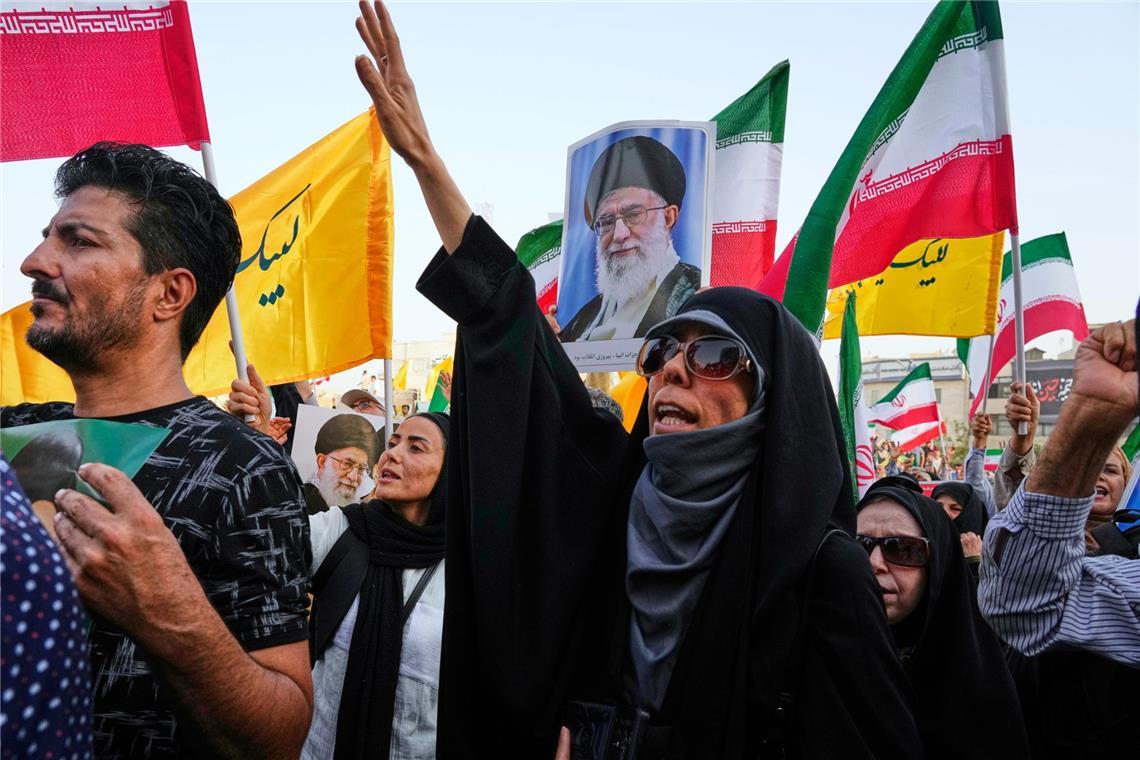 Demonstranten tragen iranische Nationalflaggen und Plakate des Obersten Führers Ajatollah Ali Chamenei, während sie Parolen gegen die USA und Israel skandieren.