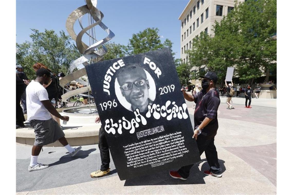 Demonstranten tragen während einer Kundgebung vor dem Polizeirevier wegen des Todes von Elijah McClain ein Plakat mit dessen Bild. Foto: David Zalubowski/AP/dpa