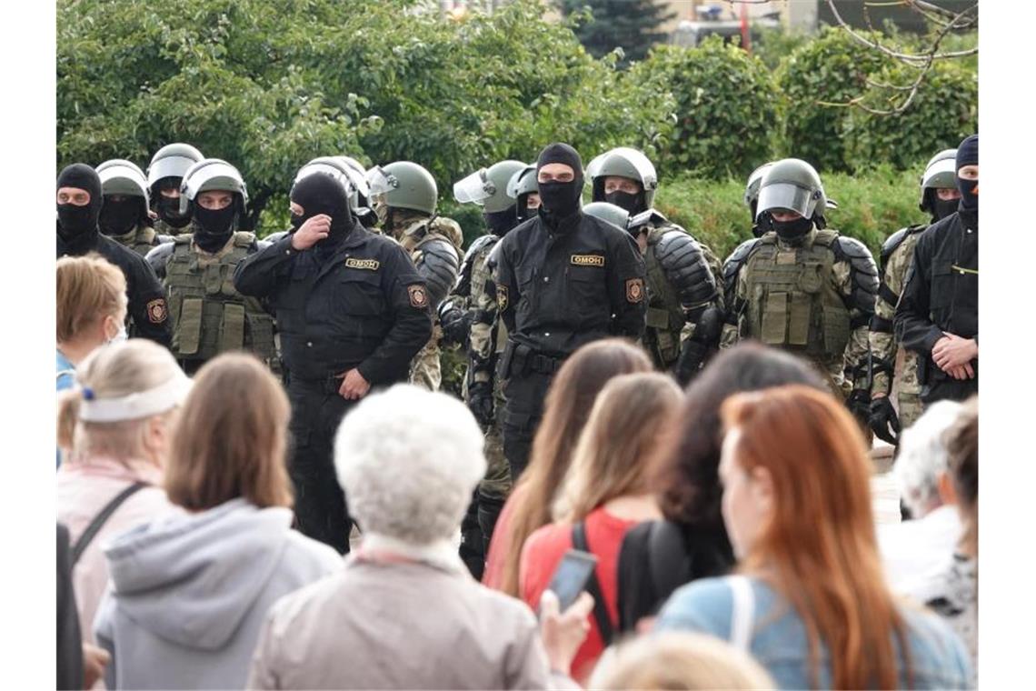 Demonstranten und Einsatzkräfte der Sonderpolizei OMON stehen sich am Unabhängigkeitsplatz in Minsk gegenüber. Foto: Ulf Mauder/dpa