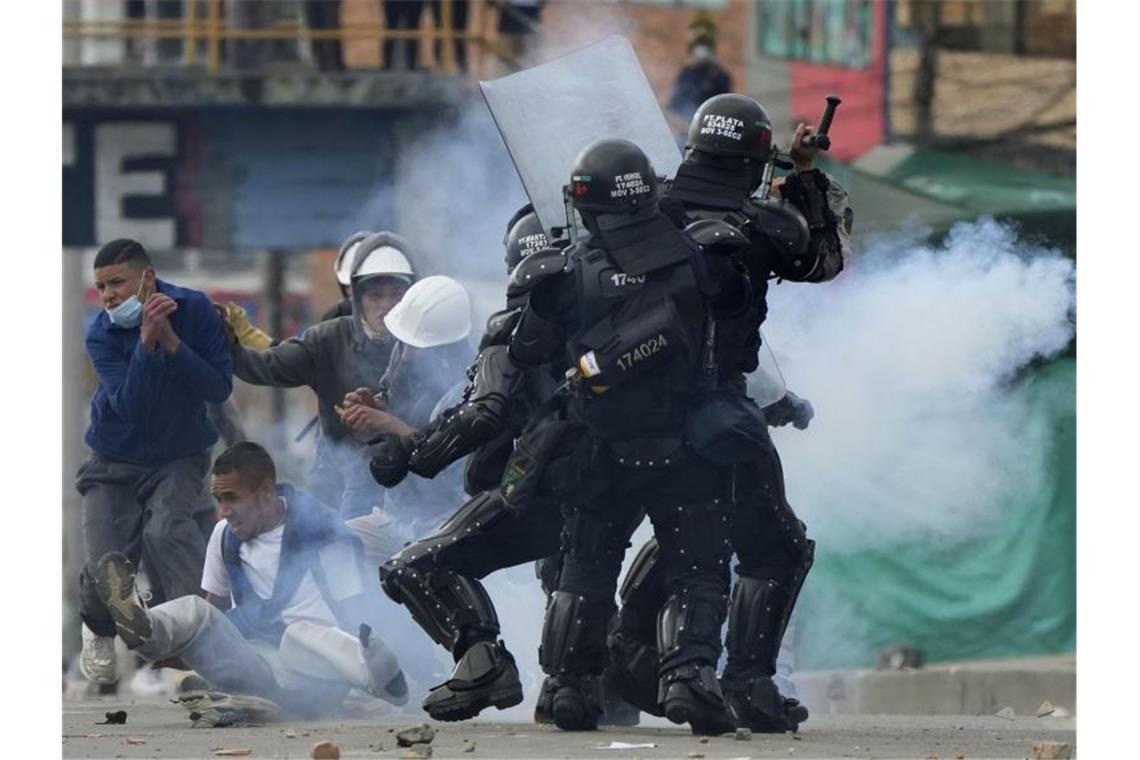 Demonstranten und Polizeibeamte geraten in Bogotá einander. Foto: Fernando Vergara/AP/dpa