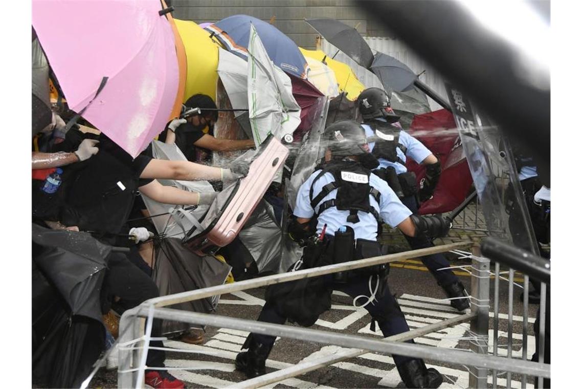 Demonstranten und Polizisten geraten aneinander. Polizisten setzen Schlagstöcke und Pfefferspray ein. Foto: Kyodo