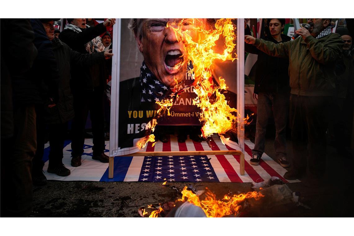 Demonstranten verbrennen ein Poster von US-Präsident Trump während einer Kundgebung gegen die USA und Israel zur Unterstützung der iranischen Regierung vor dem US-Konsulat in Istanbul.