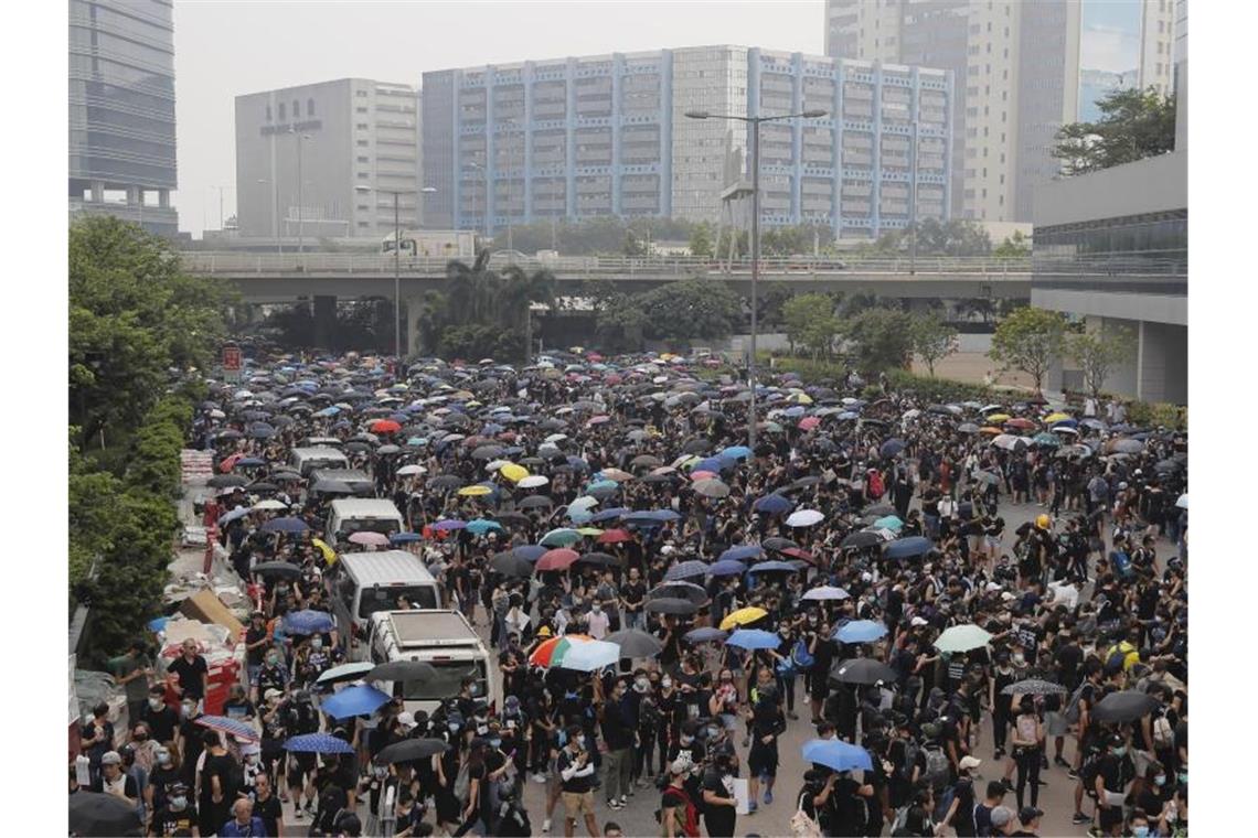 Demonstranten versammeln sich auf einer Straße. In Hongkong kommt es seit mehr als zwei Monaten immer wieder zu massiven regierungskritischen Protesten. Foto: Kin Cheung/AP