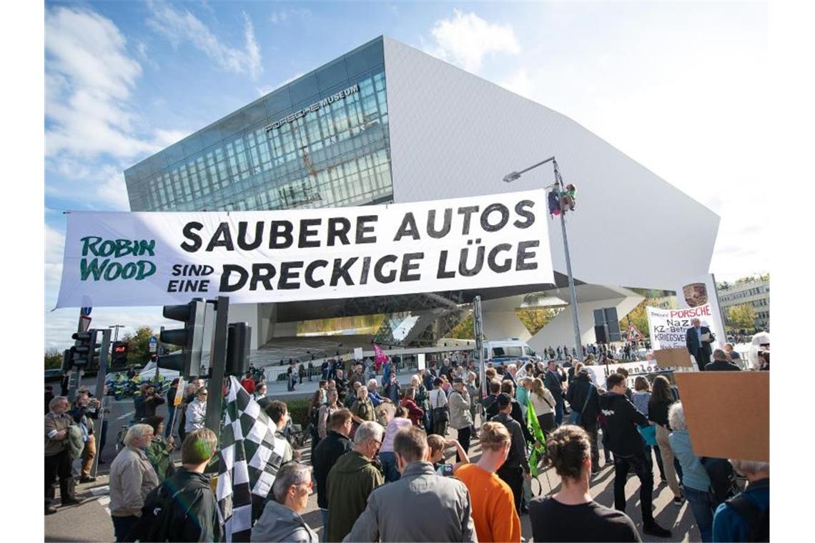 Demonstranten von Robin Wood spannen während der "Handelsblatt"-Tagung "Autogipfel 2019" vor dem Porsche-Museum einen Banner mit der Aufschrift "Saubere Autos sind eine dreckige Lüge". Foto: Sebastian Gollnow/dpa