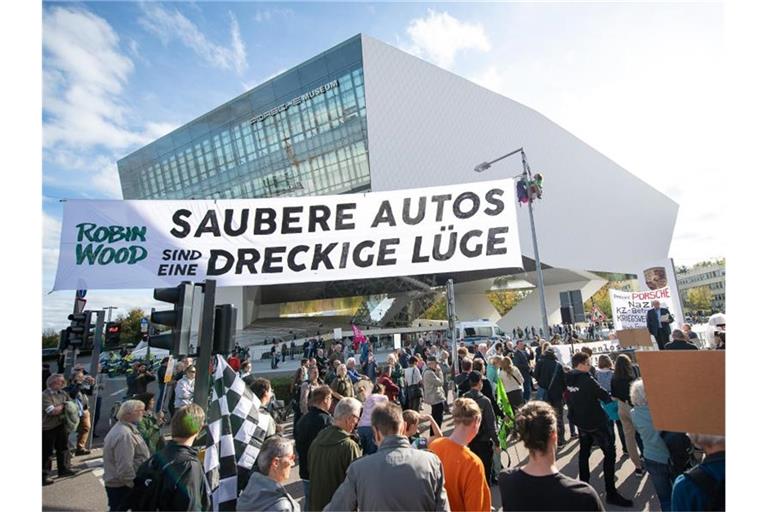 Demonstranten von Robin Wood spannen während der "Handelsblatt"-Tagung "Autogipfel 2019" vor dem Porsche-Museum einen Banner mit der Aufschrift "Saubere Autos sind eine dreckige Lüge". Foto: Sebastian Gollnow/dpa
