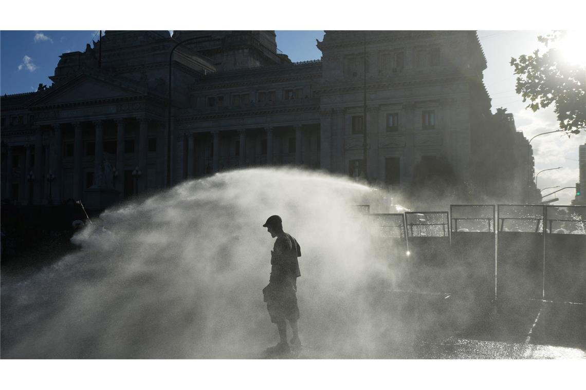 Demonstranten werden in Buenos Aires von einem Wasserwerfer der Polizei besprüht.