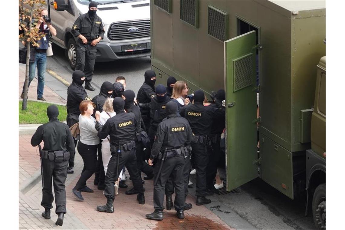 Demonstranten werden in Minsk von Bereitschaftspolizisten in einen Gefangenentransporter gebracht. Foto: Ulf Mauder/dpa
