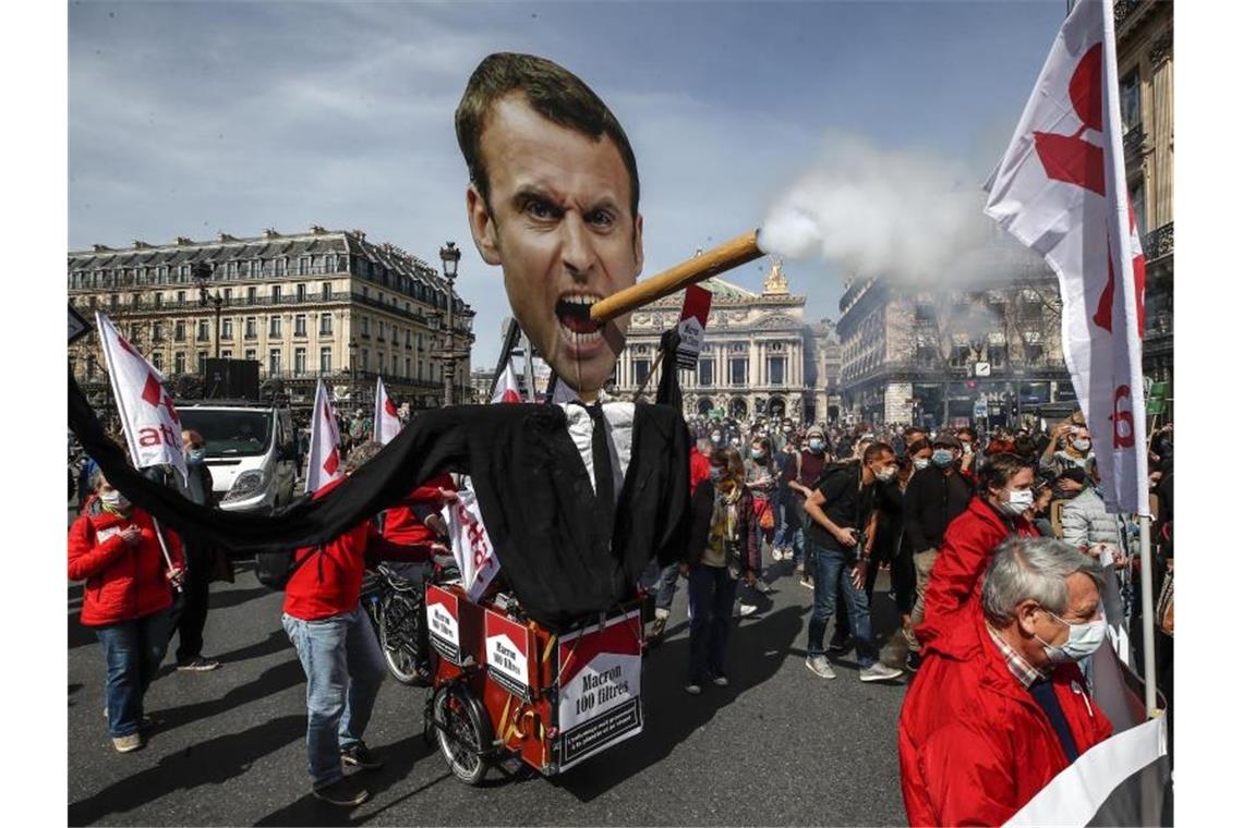 Demonstrationen für beherztere Klimapolitik in Frankreich Demonstranten ziehen mit einem Zigarre rauchenden Abbild des französischen Präsidenten Macron durch Paris. Foto: Michel Euler/AP/dpa