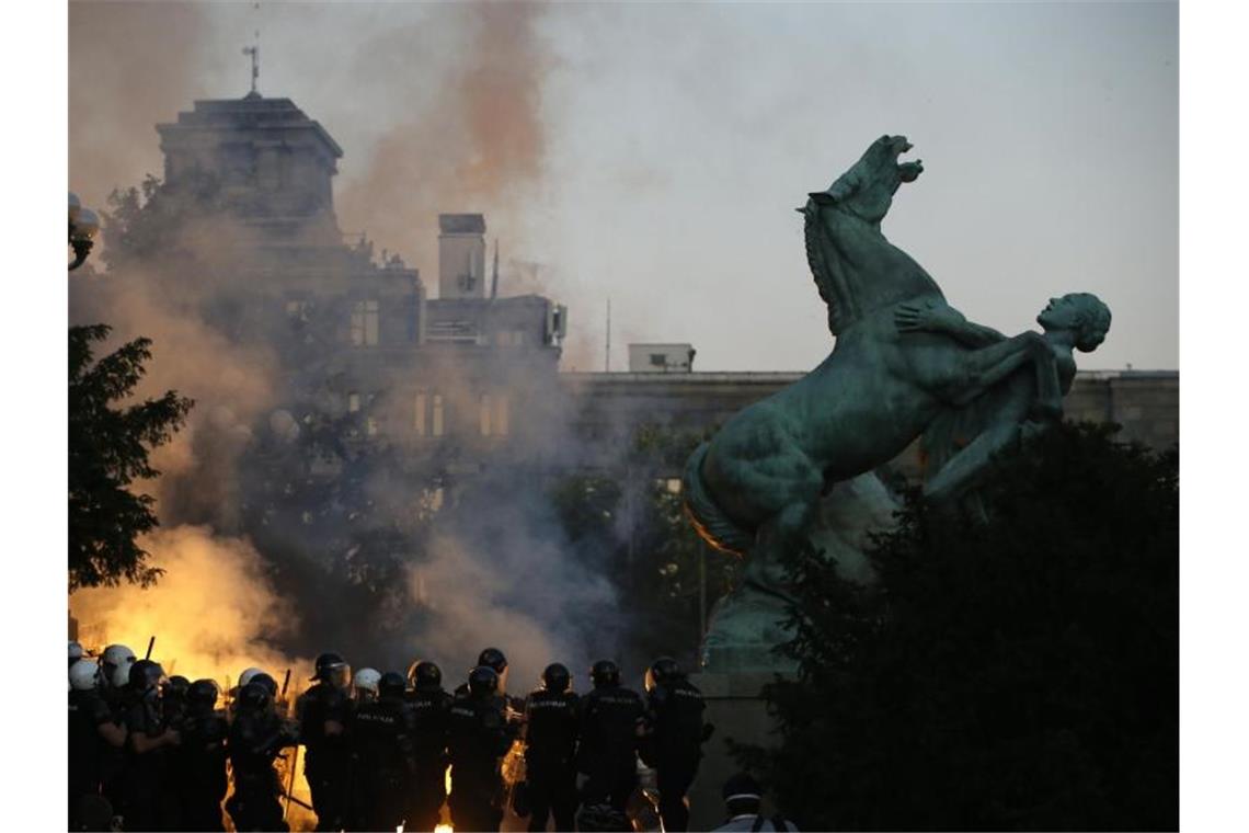 Demonstranten zünden bei einem Zusammenstoß mit Polizisten Fackeln an. Foto: Darko Vojinovic/AP/dpa