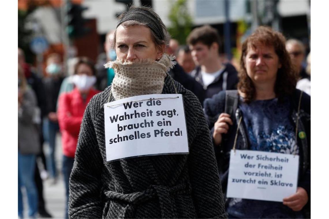 Demonstrantinnen in Hamburg haben sich Schilder umgehängt. Foto: Markus Scholz/dpa