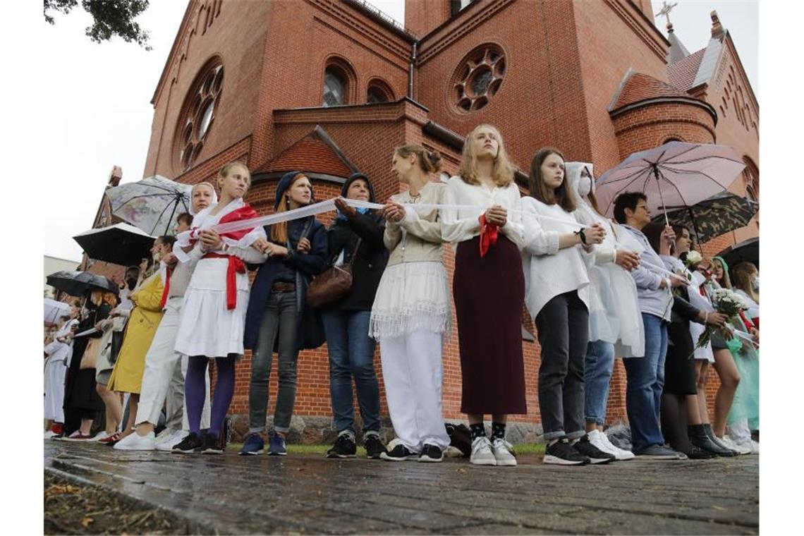 Demonstrantinnen stehen während einer Kundgebung mit einem "Warteband", einem Symbol des Protests, in Minsk. Foto: Dmitri Lovetsky/AP/dpa