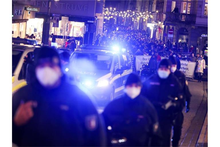 Demonstrationsteilnehmer in Begleitung der Polizei in der Innenstadt von Lübeck. Foto: Christian Charisius/dpa