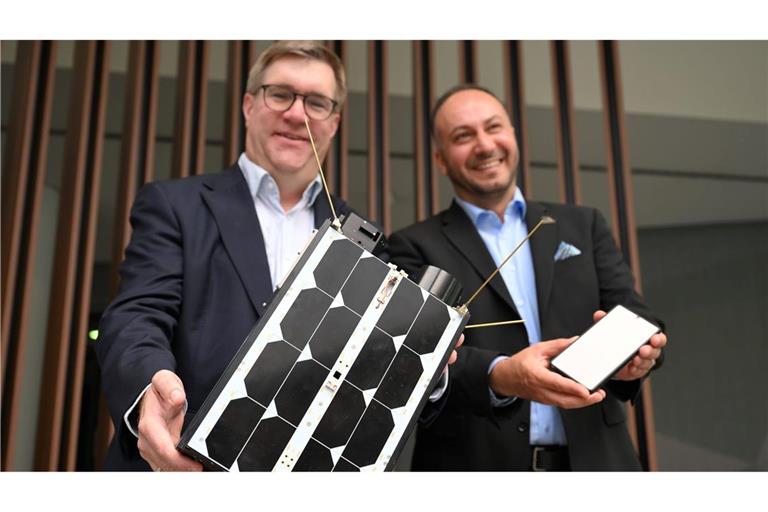 Demonstrativ gute Laune von O2-Manager Jörg Kablitz und OQ-Chef Omar Qaise, die bei der Vorstellung ihres Vorhabens ein Modell eines Satelliten dabeihatten.